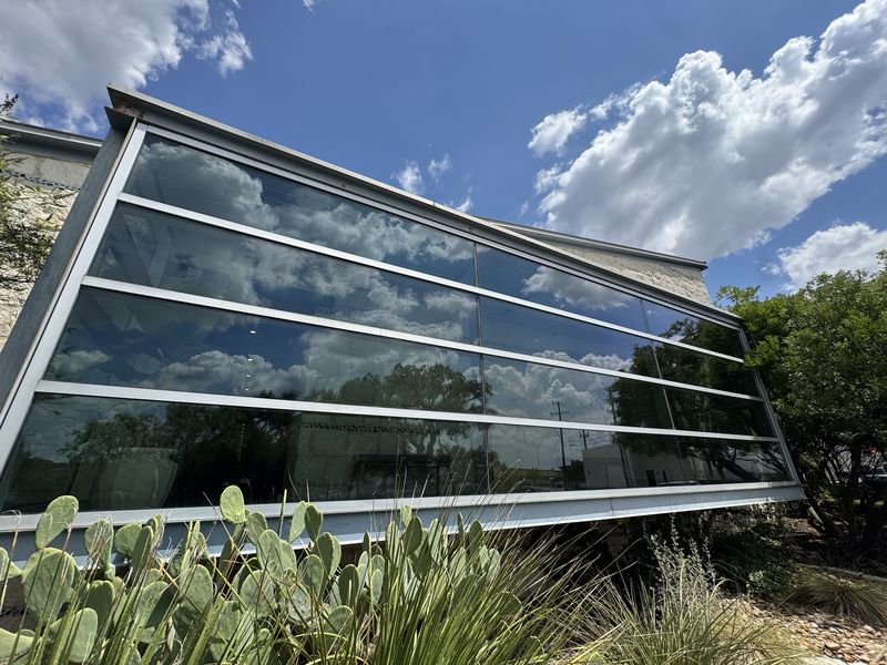 Clean commercial windows reflecting blue sky and clouds