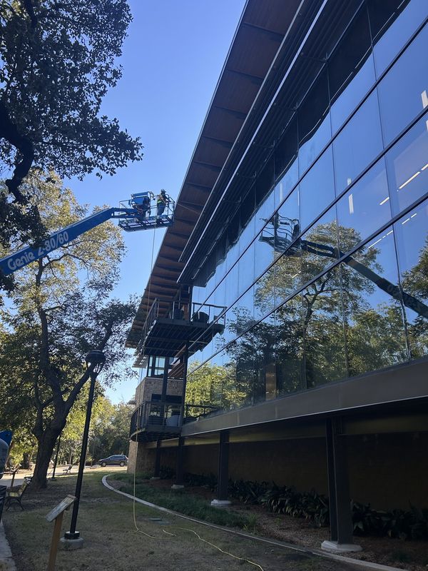 Window cleaning on a multi-story glass building from a boom lift
