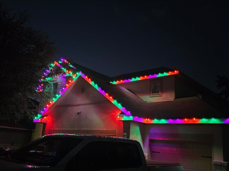 Multicolor C9 Christmas lights on a two-story home