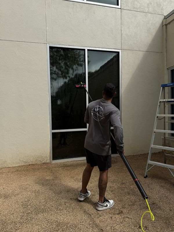 Pure View crew member cleaning commercial windows with a water-fed pole